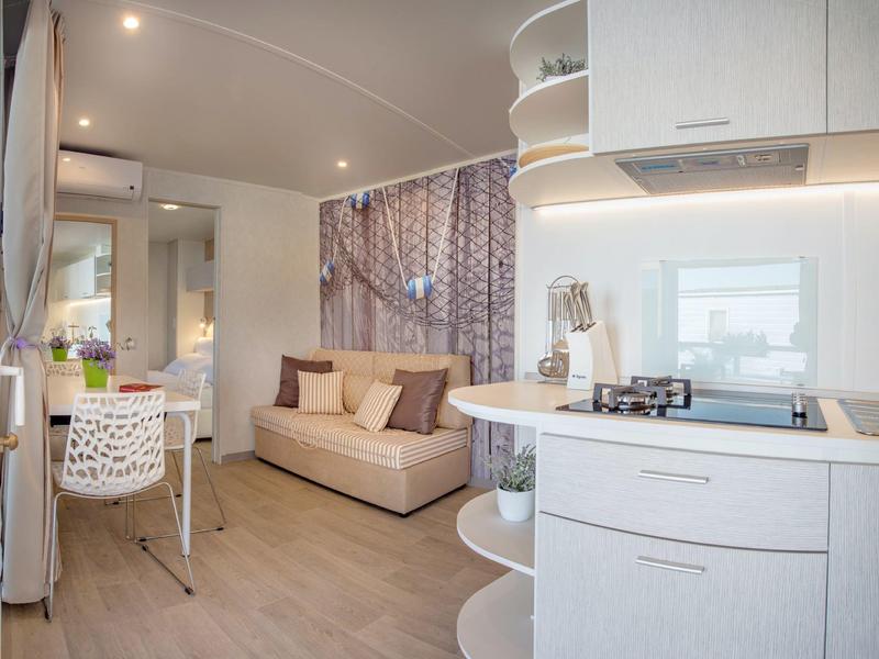 Monolocale moderno e luminoso con design pulito e zona salotto accogliente.