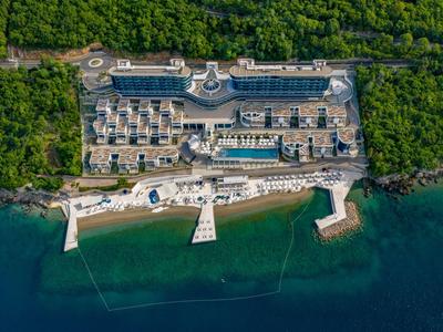 Luksusowy kurort nad wodą z basenami i prywatnymi pomostami otoczony gęstą roślinnością.