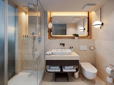 Moderní koupelna se sprchou, umyvadlem, toaletou a velkými nástěnnými zrcadly.