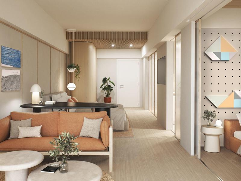 Moderní hotelový pokoj s obývací částí, postelí a neutrálními tóny.