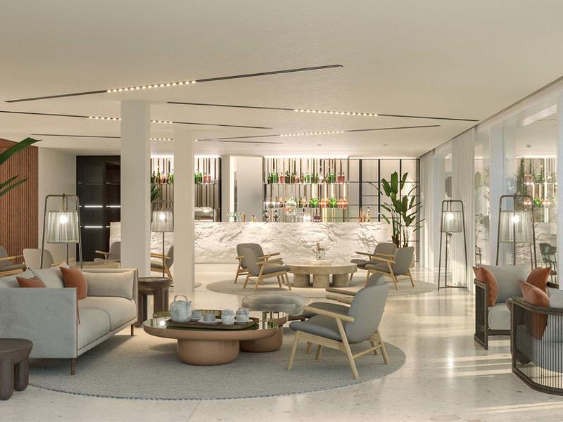 Světlý moderní hotelový salonek s velkými okny, pohodlnými posezeními a minimalistickým designem.