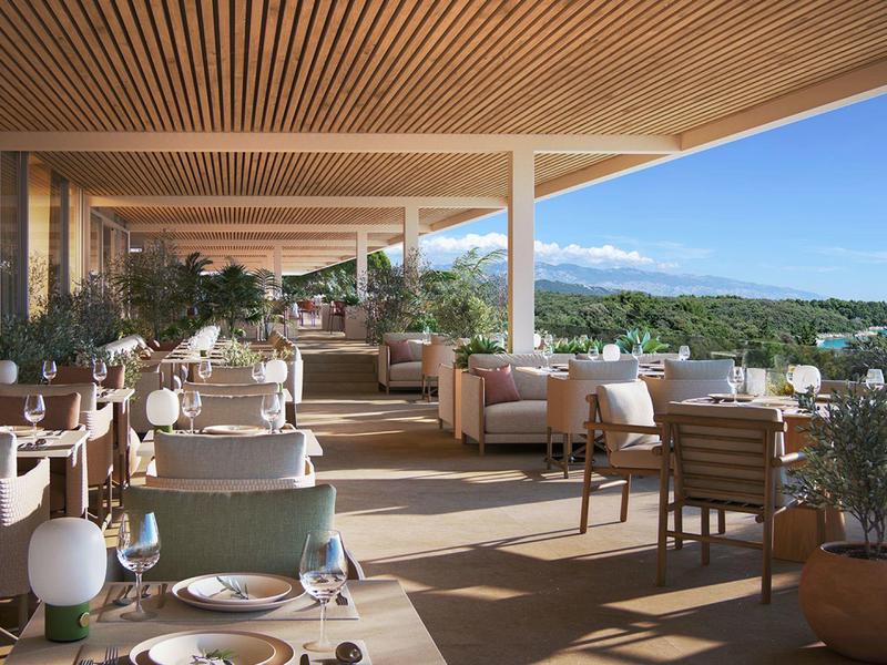 Prostorná terasa s prostřenými stoly a výhledem na zelené kopce za jasné oblohy.