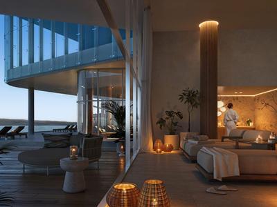 Moderner Hotelbalkon mit Sitzbereich und Blick auf ruhiges Wasser bei Dämmerung.