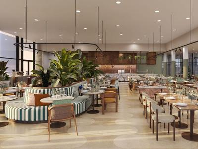 Modernes Hotelrestaurant mit gepolsterten Sitzen, Holztischen und großen Pflanzen.