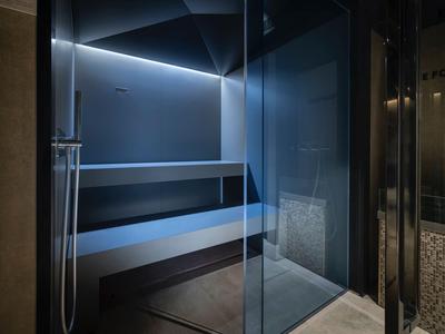 Moderner Wellnessbereich mit Dampfbad und Glaswänden in einem Hotel.