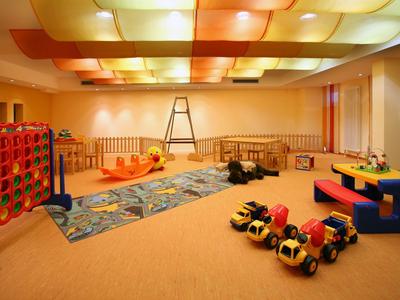 Ein helles, geräumiges Spielzimmer mit Kinderspielzeug und Teppich.