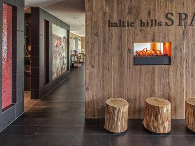 Gemütlicher Spa-Bereich mit Holzhockern, Wandkamin und natürlicher Holzverkleidung.