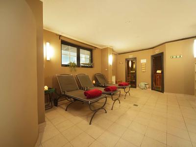 Heller, gemütlicher Zimmerbereich mit braunen Wänden, großen Fenstern und gepolsterten Stühlen mit roten Kissen.