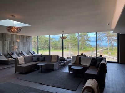 Geräumiger Hotel-Loungebereich mit modernen Sofas und großen Fenstern mit Blick auf die Natur.