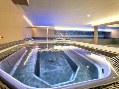 Modern hotel hot tub with indirect lighting and outdoor view.