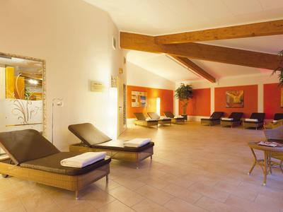 Großer, heller Wellnessraum mit Liegestühlen und warmen Holzakzenten.