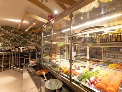 Modern buffet with salads and hot dishes in a restaurant with wooden beams.
