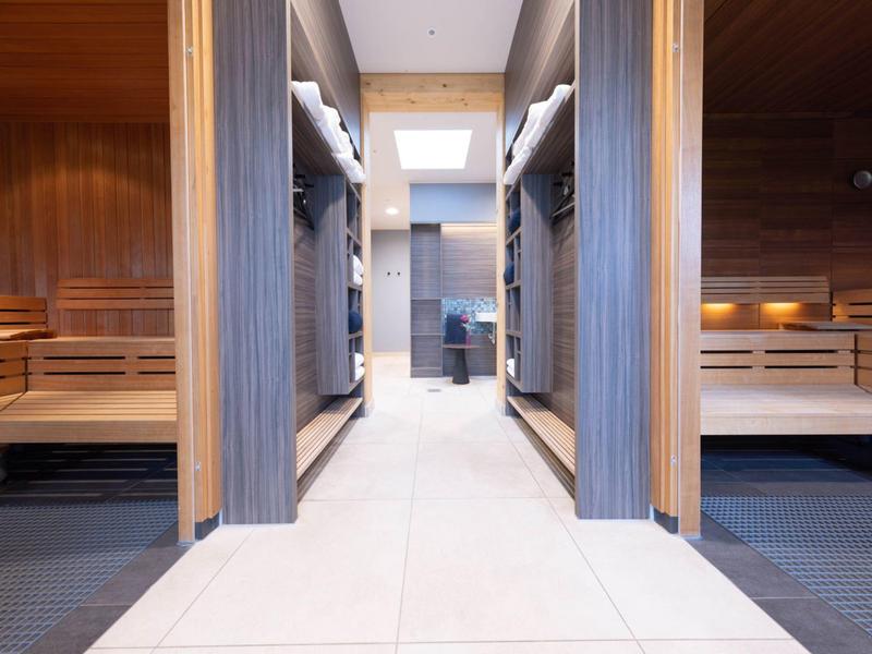 Modern sauna area with wooden panels and light tiled floor