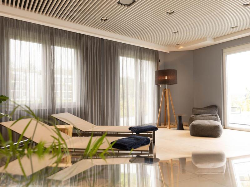 Bright, modern wellness room with lounge chairs, comfortable bean bags, and large windows.