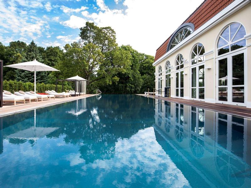 Nowoczesny basen na zewnątrz obok budynku z dużymi oknami w spokojnym otoczeniu.