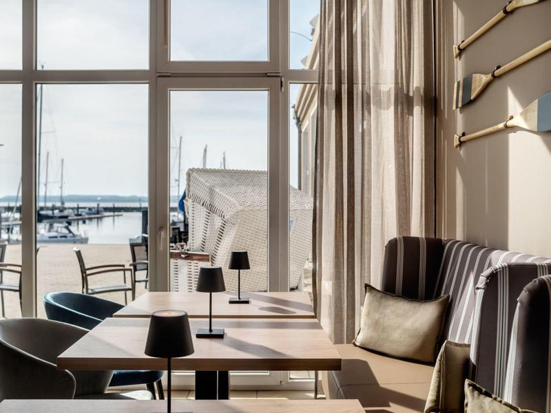 Bright café overlooking the harbor, cozy seating areas, and modern decor.
