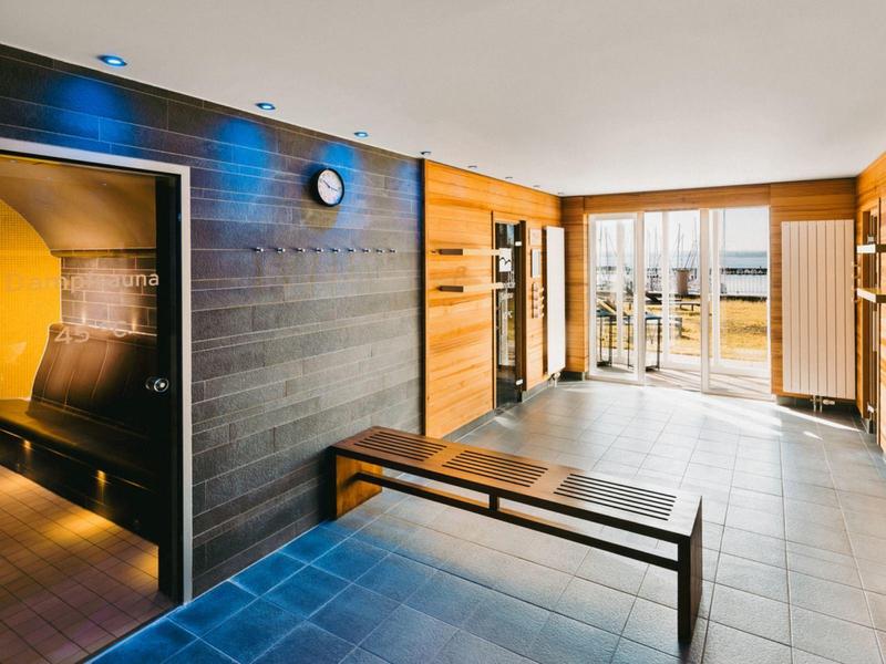Bright sauna with wooden walls, bench, and large window overlooking outdoors.