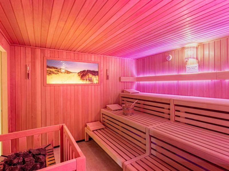 Intérieur d'un sauna avec panneaux en bois et éclairage rose