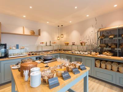 Jasný snídaňový bufet s různými druhy chleba a pomazánek v moderní kuchyni.