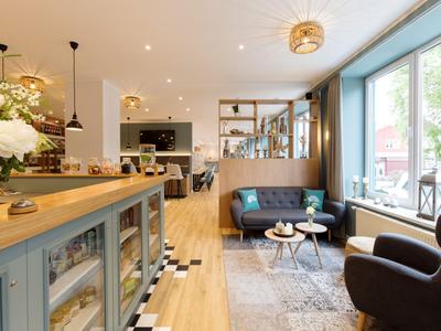 Pohodlná hotelová lounge s posezením, velkými okny a moderním zařízením.