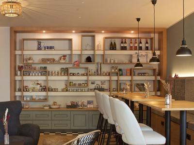 Příjemný moderní jídelní prostor s policemi plnými sklenic a lahví, stoly a židlemi.