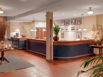 Elegancka recepcja hotelowa z ladą, lampami i ciepłym oświetleniem.