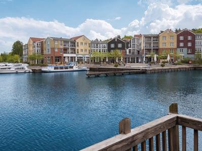 Blick auf einen Hafen mit bunten Häusern und Booten bei klarem Himmel.