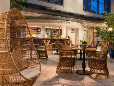 Gemütliche Outdoor-Sitzecke mit Korbmöbeln und warmem Licht in einem Hotelrestaurant.