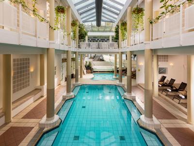 Elegant indoor pool with columns and lounge chairs in a luxury hotel