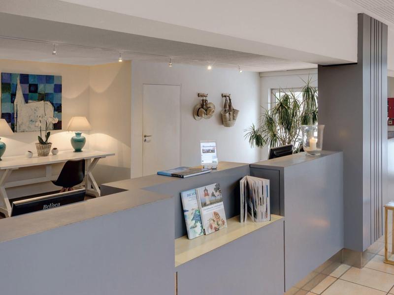 Bright, modern hotel lobby with reception, stylish decor, and comfortable seating areas.