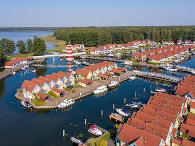 Luftaufnahme eines Ferienresorts mit Wasserwegen und roten Dächern, umgeben von Bäumen.