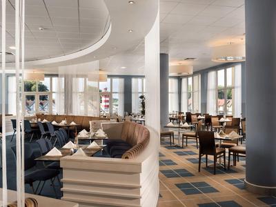 Modernes Hotelrestaurant mit elegant gedeckten Tischen und bequemen Sitzgelegenheiten.