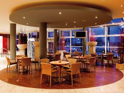 Moderner Hotel-Loungebereich mit runden Tischen und großen Fenstern