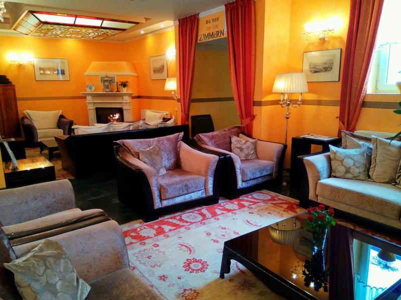 Interior of a cozy hotel lounge with comfortable armchairs and warm yellow walls.