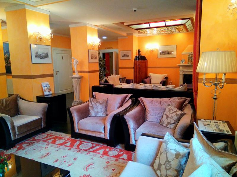 Cozy hotel lounge area with comfortable armchairs, warm orange walls, and a carpet.