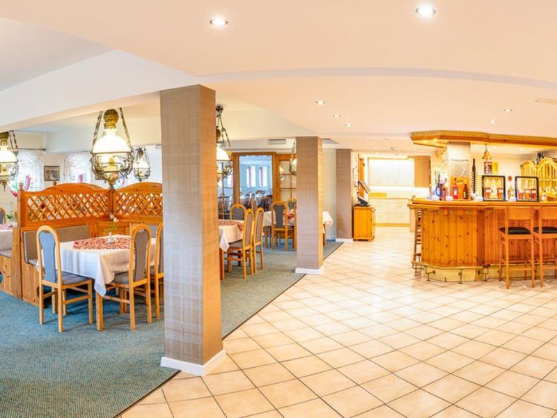 Bright hotel lobby with bar, seating areas, and decorative furnishings.