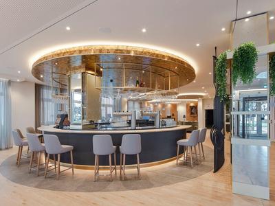Espace lounge d'hôtel moderne avec bar rond, sièges et éclairage élégant