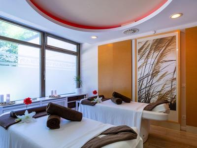 Sala massaggi luminosa con due lettini da trattamento e elementi decorativi.