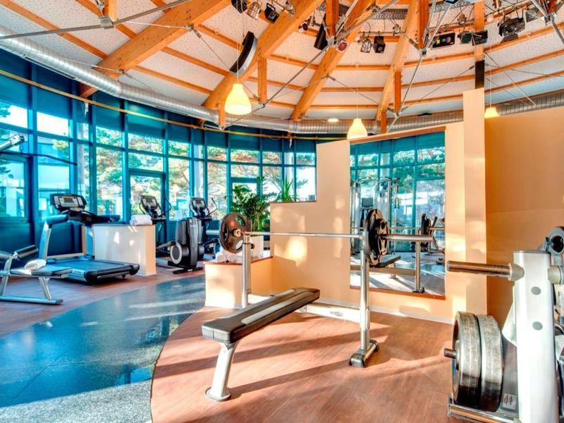 Světelná posilovna s moderním vybavením a velkými okny v hotelu.