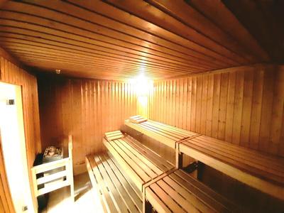 Holzsauna mit mehrstufigen Holzliegen und warmem gelbem Licht an der Decke.