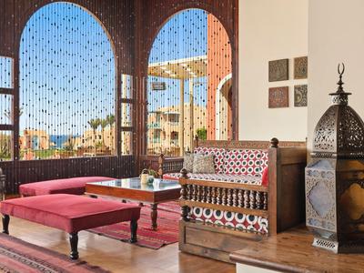 Gemütliche Sitzecke mit orientalischem Stil und Blick auf die Stadt durch dekorative Fenster.