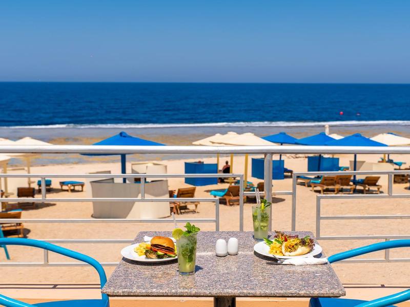 Uitzicht op het strand en de zee vanaf een tafel in een strandrestaurant met eten en drinken.
