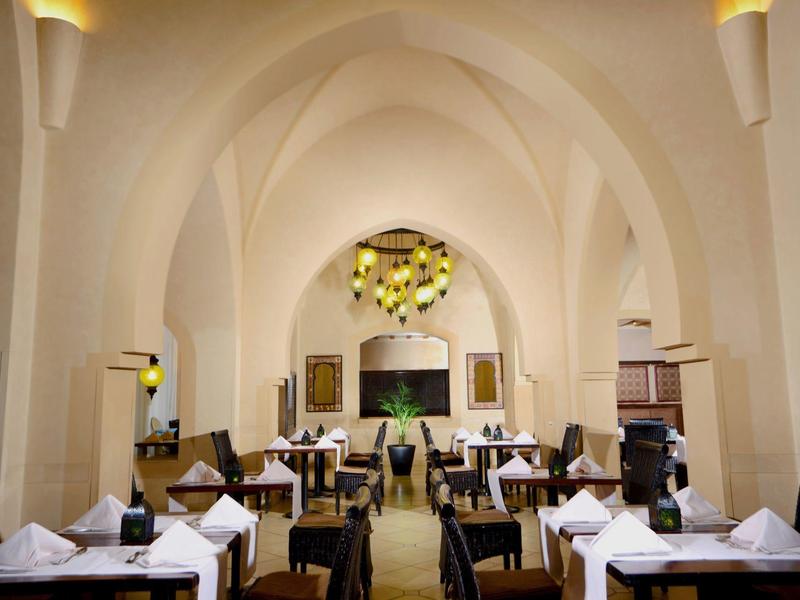 Elegant restaurant met gewelfde plafond en netjes gedekte tafels.