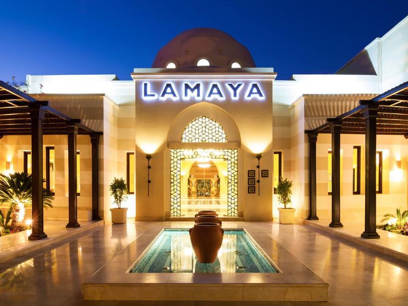 Elegant hotel courtyard with water feature and oriental architectural design at night.