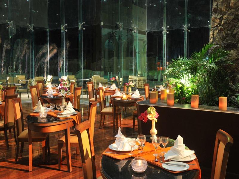 Elegantes Restaurant mit hölzernen Tischen und Stühlen, geschmückt mit Blumen und Kerzenlicht.