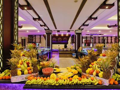 Buffet con frutas exóticas y luz violeta en un elegante restaurante de hotel.