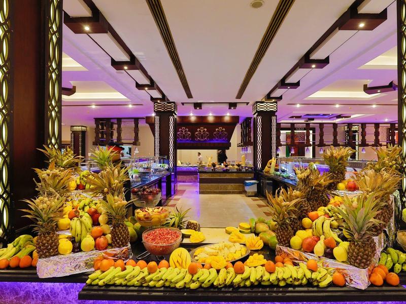 Buffet con frutas exóticas y luz violeta en un elegante restaurante de hotel.