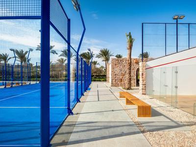 Terrain de tennis moderne avec surface bleue et bancs en plein air ensoleillé