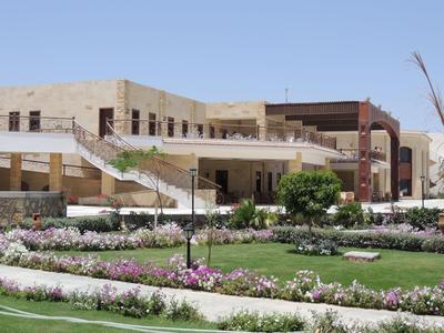 Edificio di hotel moderno con terrazze e giardino curato sotto un cielo sereno