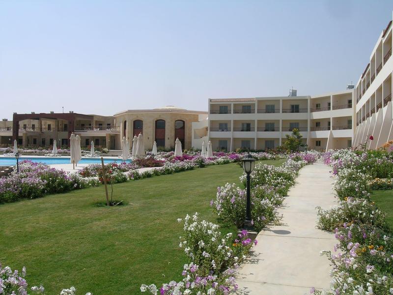 Edificio dell'hotel con piscina e giardino curato con piante fiorite